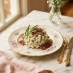 Creamy round swamp chicken salad piled on a floral gold-rim plate with celery and tarragon visible
